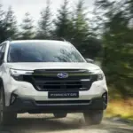 Subaru Forester e-BOXER, weiß, fährt auf einem unbefestigten Weg durch einen Wald.