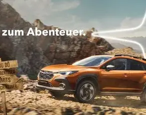 Subaru Crosstrek fährt über eine Schotterpiste in den Bergen, Outdoor-Prämienhinweis im Bild.