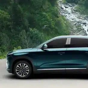 Togg T10X Elektro-SUV in blauer Lackierung vor einer natürlichen Waldkulisse, Seitenansicht.