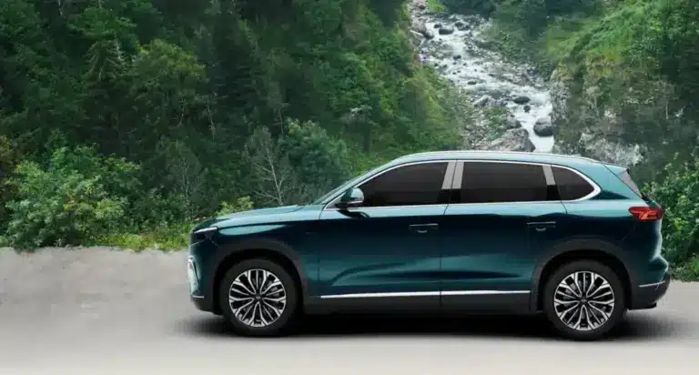 Togg T10X Elektro-SUV in blauer Lackierung vor einer natürlichen Waldkulisse, Seitenansicht.