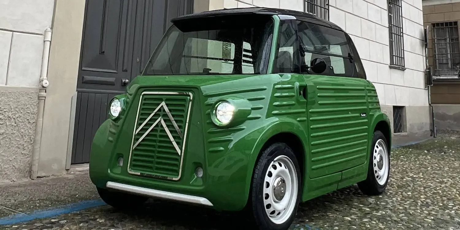 TYPE-AMI MicroCar von Caselani, grün, im Retro-Look mit HY-Anklängen, vor einem Stadthaus geparkt