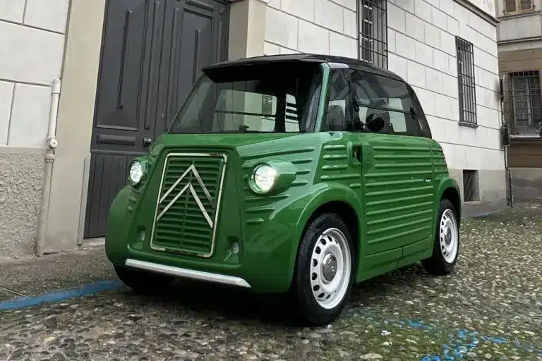 TYPE-AMI MicroCar von Caselani, grün, im Retro-Look mit HY-Anklängen, vor einem Stadthaus geparkt