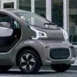 XEV YOYO, ein kleines, modernes Elektroauto für die Stadt, seitlich vor Gebäuden geparkt