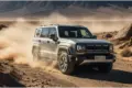 BAIC BJ40 Pro Offroader auf Schotterpiste in bergiger Wüstenlandschaft mit aufgewirbeltem Staub