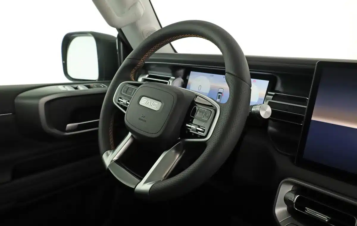Innenansicht des BAIC BJ40 Pro mit Lenkrad und digitalen Anzeigen.