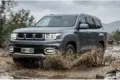 BAIC BJ60 Flagship fährt bei Regen durch Matsch auf einer unbefestigten Straße im Gelände.
