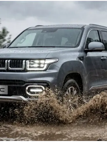 BAIC BJ60 Flagship fährt bei Regen durch Matsch auf einer unbefestigten Straße im Gelände.