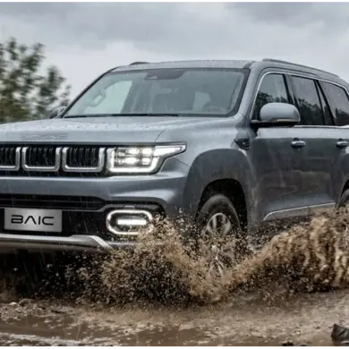 BAIC BJ60 Flagship fährt bei Regen durch Matsch auf einer unbefestigten Straße im Gelände.