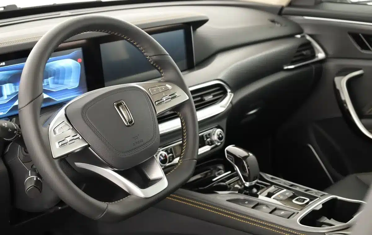 Detailaufnahme des Innenraums mit Lenkrad, großem Bildschirm und Mittelkonsole im Bestune T77 Pro