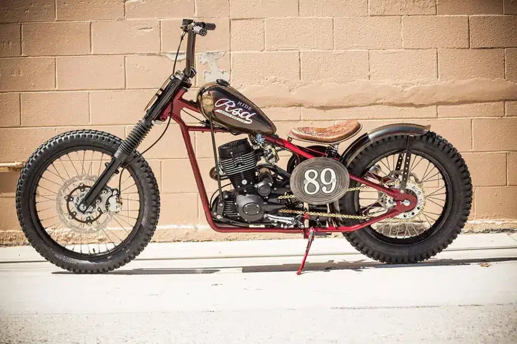 Motorrad Cleveland CycleWerks Heist als puristischer Chopper-Umbau mit Starrrahmen und Einzelanfertigungen, seitlich vor einer Backsteinwand fotografiert.