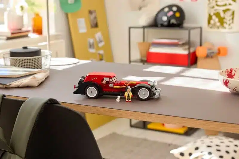 Cruella de Vils Auto aus LEGO mit Minifigur und Dalmatiner auf einem Tisch