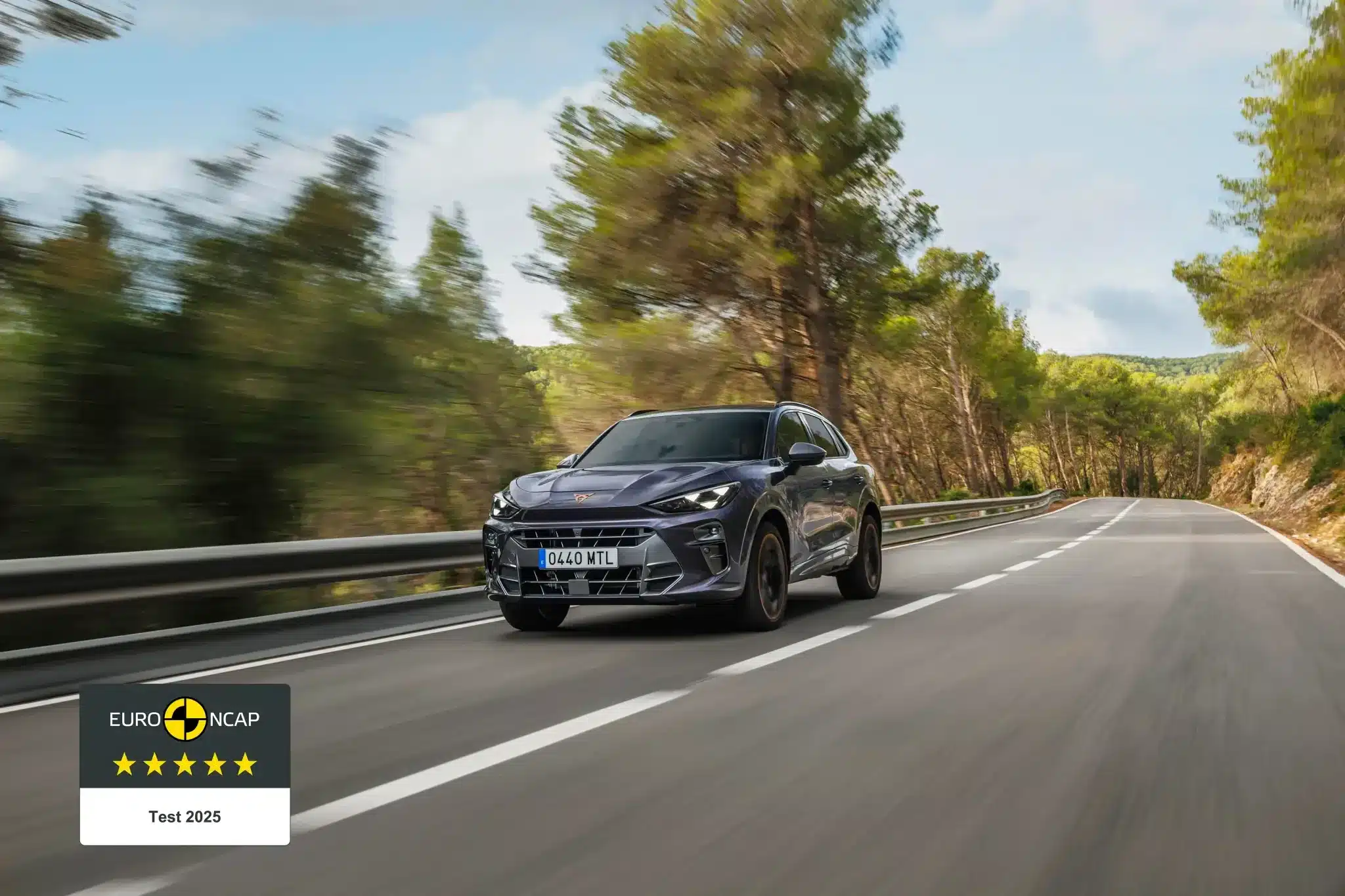 Der CUPRA Terramar fährt dynamisch auf einer Landstraße, umgeben von Bäumen.
