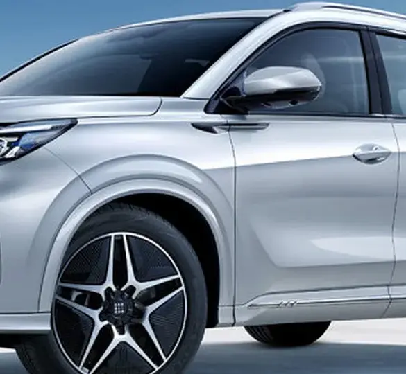 DFSK Fengon E5 PHEV in Silber steht an einer Ladesäule vor blauem Himmel.