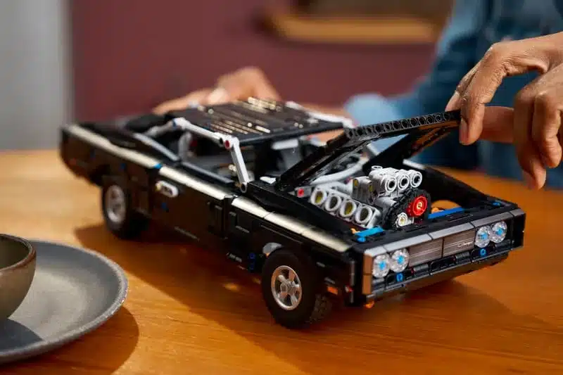 LEGO Technic Modell des Dodge Charger R/T mit geöffnetem Motorraum und sichtbarem V8-Motor, auf einem Holztisch