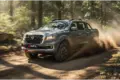 DONGFENG Rich 6 Pick-up fährt dynamisch auf einem Waldweg und wirbelt Staub auf