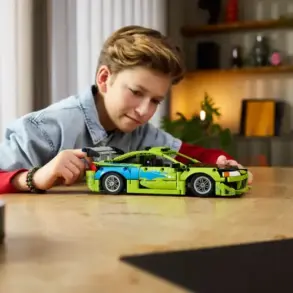 Ein Junge steuert das aufgebaute LEGO Technic Modell des Mitsubishi Eclipse aus Fast & Furious auf einem Tisch.