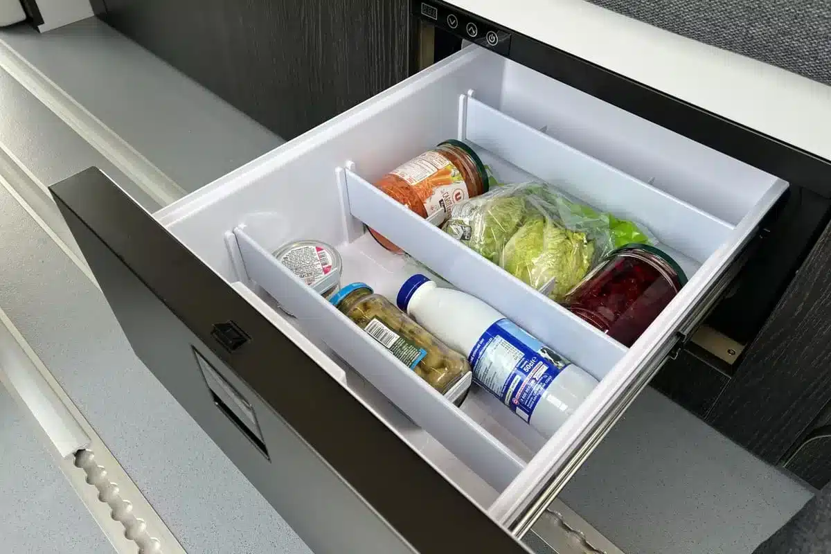 Offener Kompressorkühlschrank mit Lebensmitteln im Innenraum des Flex PLUS Campervans