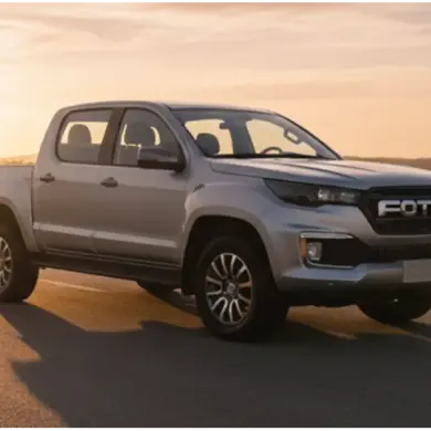 Foton 3 Pick-up in Silber fährt bei Sonnenuntergang auf einer Landstraße in ländlicher Umgebung.