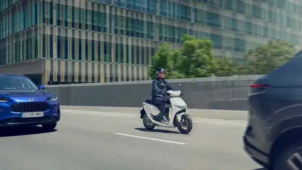 Person fährt den Honda CUV e: Elektro-Roller auf einer urbanen Straße im Alltag