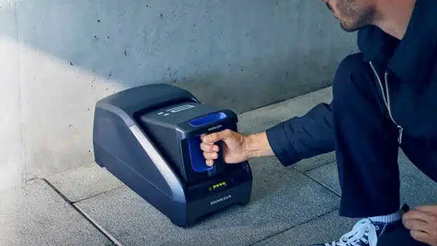 Person legt die Hand in einen stationären Fingerabdruckscanner.