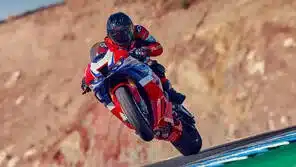 Honda CBR1000RR-R Fireblade mit Fahrer auf der Rennstrecke, Vorderrad in der Luft