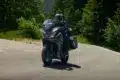 Honda NT1100 2026 mit zwei Fahrern auf Landstraße, Seitenkoffer und Windschutz gut sichtbar.