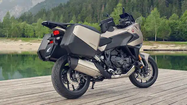 Honda NT1100 2026 mit Gepäckkoffern auf einem Steg vor See und Wald