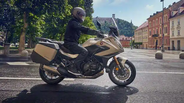 Fahrer auf einer Honda NT1100 2026 mit Seitenkoffern fährt durch eine europäische Stadt.