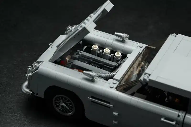 Geöffnete Motorhaube des LEGO James Bond Aston Martin DB5 mit sichtbarem Sechszylinder-Reihenmotor.