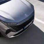 Detailansicht der Fahrzeugfront eines MG Elektro-SUV mit markantem Kühlergrill und Scheinwerfern