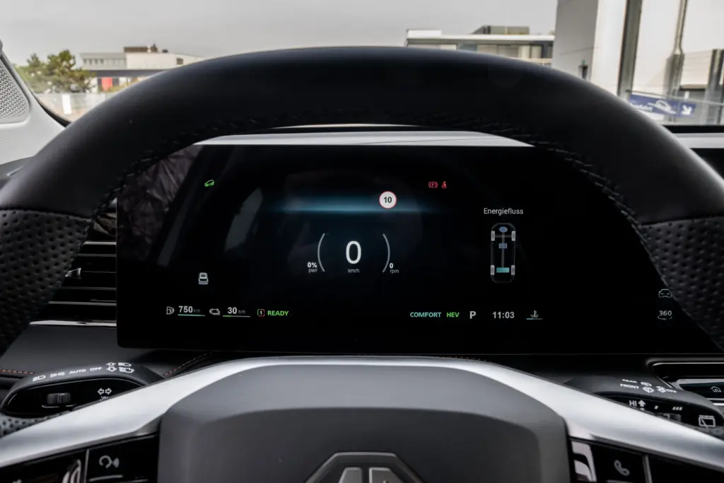 Digitales Instrumentendisplay eines MG Hybridautos mit Energieflussanzeige hinter dem Lenkrad