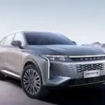 OMODA 9 PHEV in Exeed White, stehend auf offenem Terrain, mit markanter Front und Diamant-Kühlergrill.
