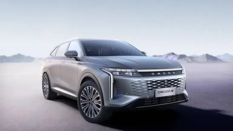 OMODA 9 PHEV in Exeed White, stehend auf offenem Terrain, mit markanter Front und Diamant-Kühlergrill.