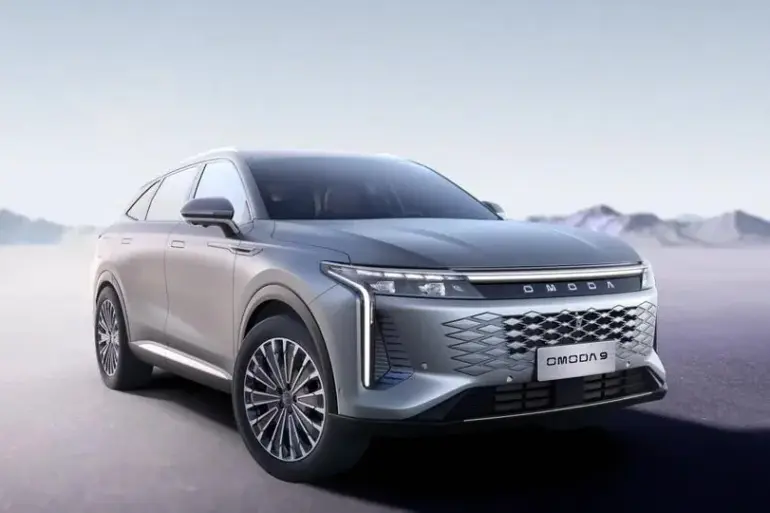 OMODA 9 PHEV in Exeed White, stehend auf offenem Terrain, mit markanter Front und Diamant-Kühlergrill.