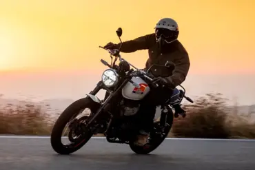 Motorradfahrer auf der Royal Enfield Bear 650 Road Scrambler, aufgenommen bei Sonnenuntergang.