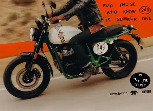 Royal Enfield Bear 650 Road Scrambler, Startnummer 249, Seitenansicht in Bewegung, Motorradfahrer mit Lederjacke.