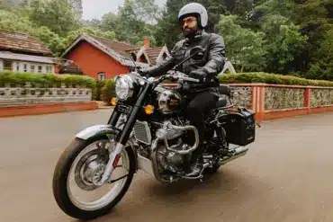Fahrer auf einer Royal Enfield Classic 650 beim Fahren durch eine Ortschaft