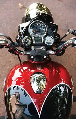 Cockpitansicht mit Tacho und Tank der Royal Enfield Goan Classic 350 Bobber, Farbe Rave Red
