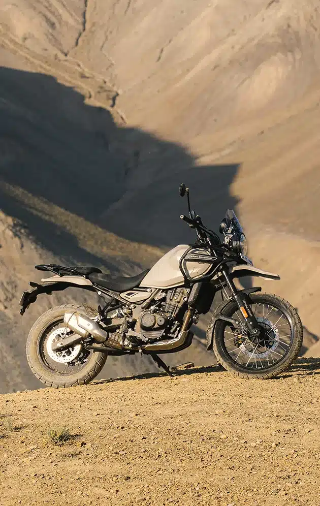 Royal Enfield Himalayan 450 stehend auf sandigem, bergigem Gelände