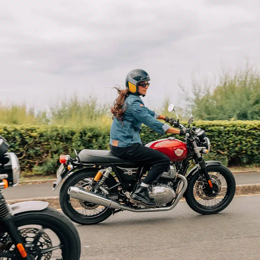 Fahrende Royal Enfield Interceptor 650 auf einer Straße, klassische Naked-Bike-Optik mit rotem Tank.