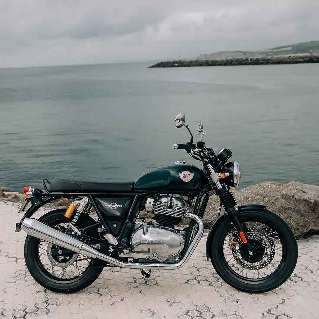 Royal Enfield Interceptor 650, klassisches Naked Bike, seitlich fotografiert vor ruhigem Wasser.