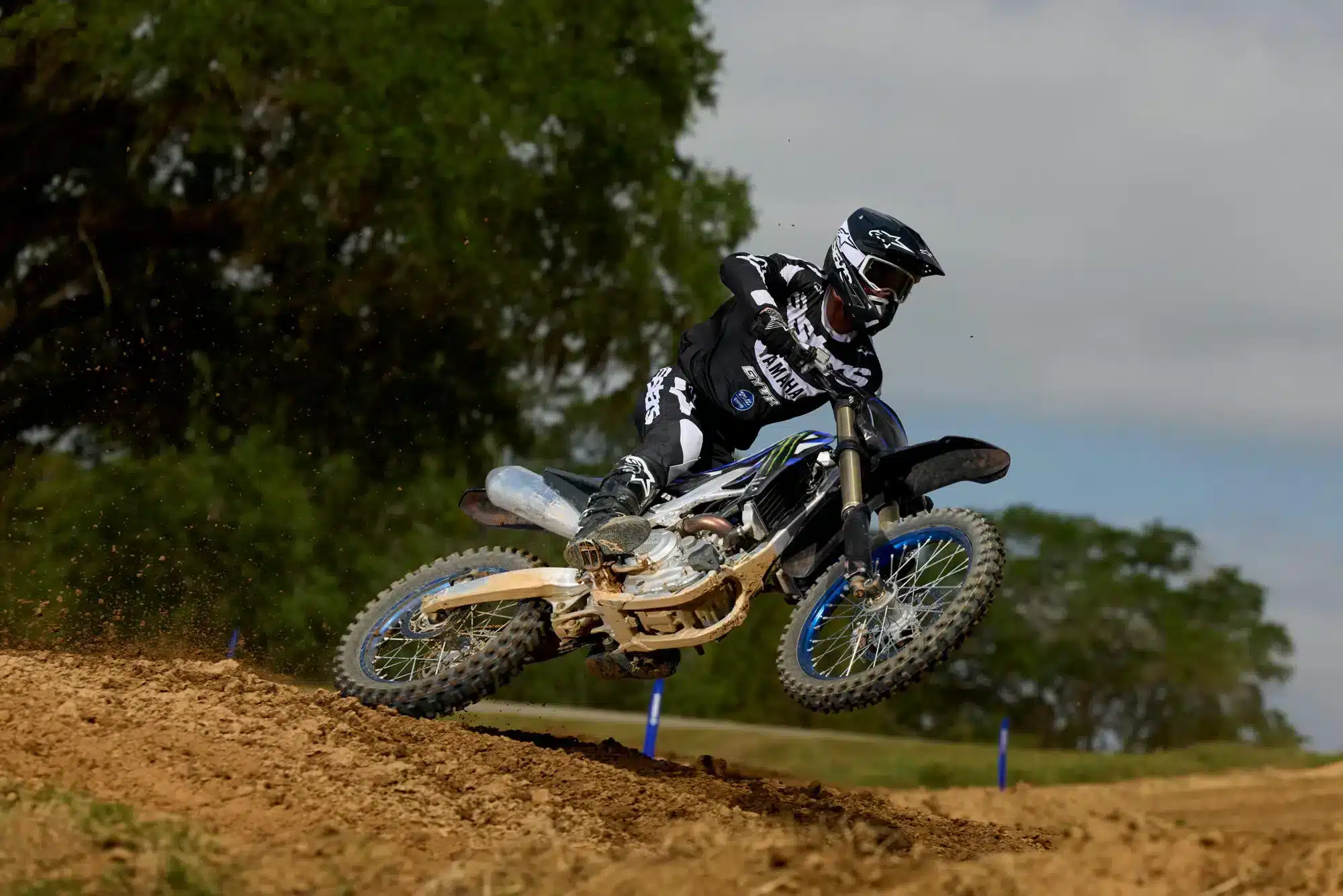Motocross-Fahrer fährt eine Yamaha YZ250F Monster Energy Yamaha Racing Edition dynamisch über eine Offroad-Piste