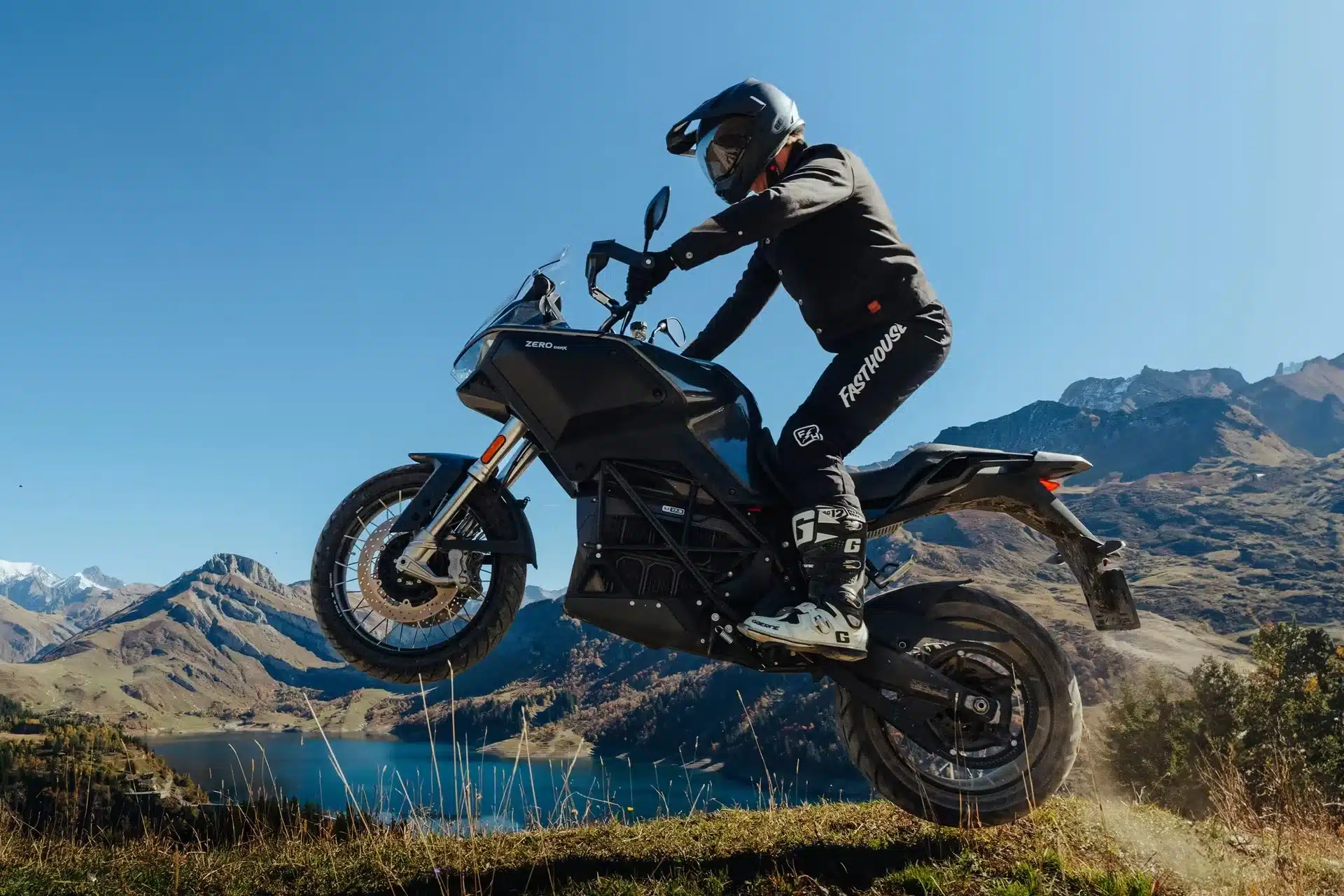 Zero DSR/X Elektro-Adventure-Bike mit Fahrer beim Sprung in alpiner Landschaft