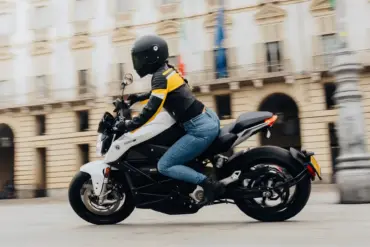 Fahrerin auf einer weißen Zero S Z-Force 15,6+ 11 kW fährt durch die Stadt.